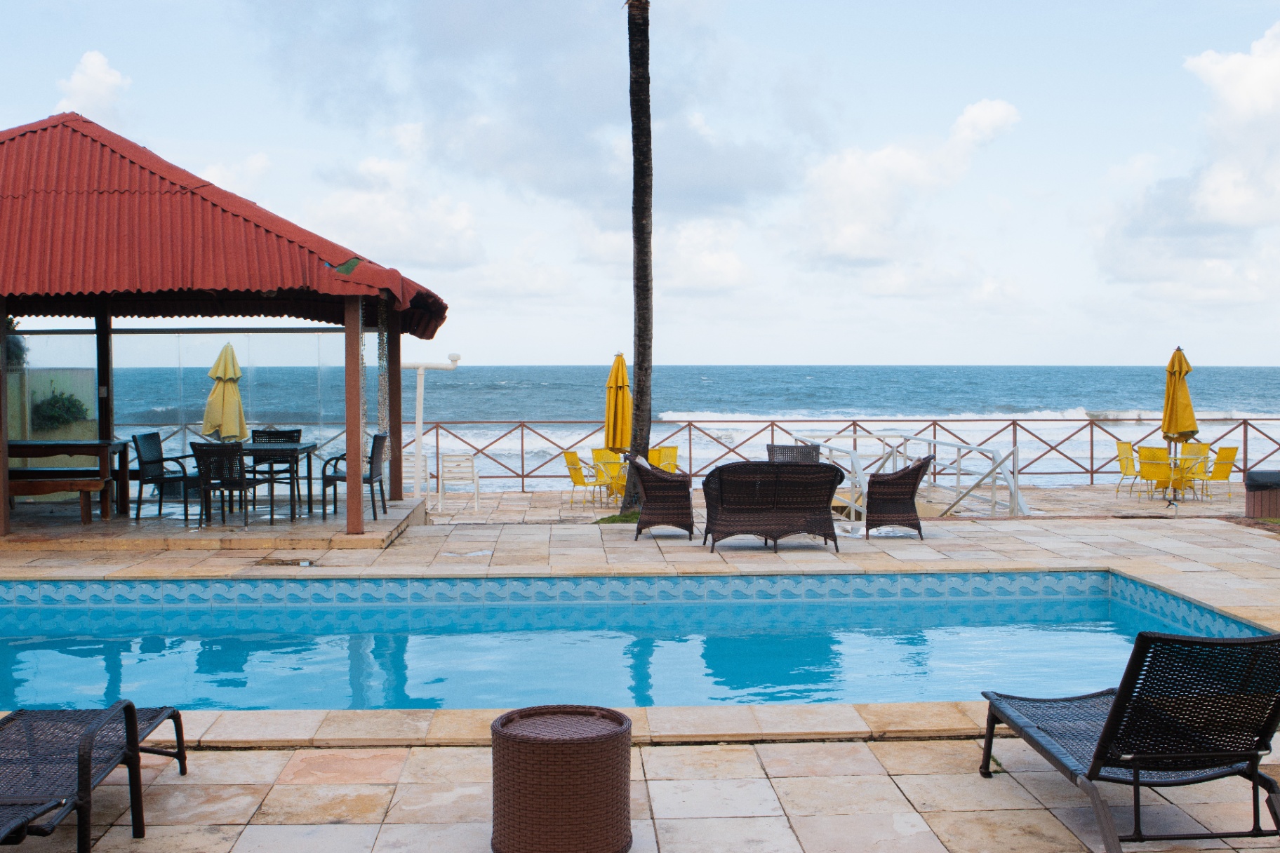 Piscina com deck coberto à beira-mar